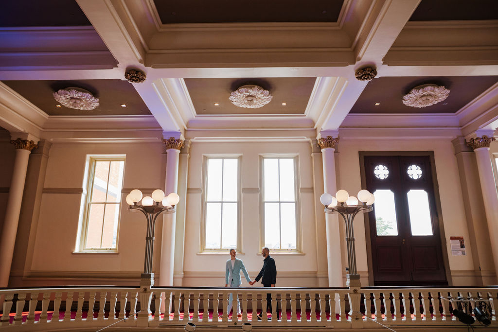 Natural light through large windows behind the couple, who are standing in a loft at Cincinnati Music Hall.