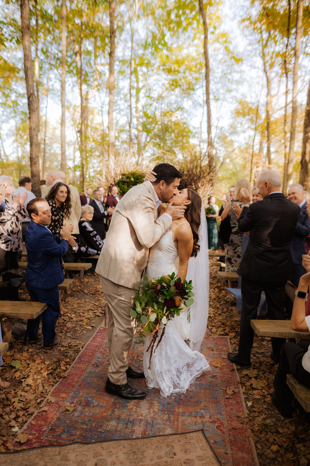 Amber and Evan walking down the aisle at their Canyon Run Ranch wedding in Troy Ohio surrounded by guests in a wooded ceremony